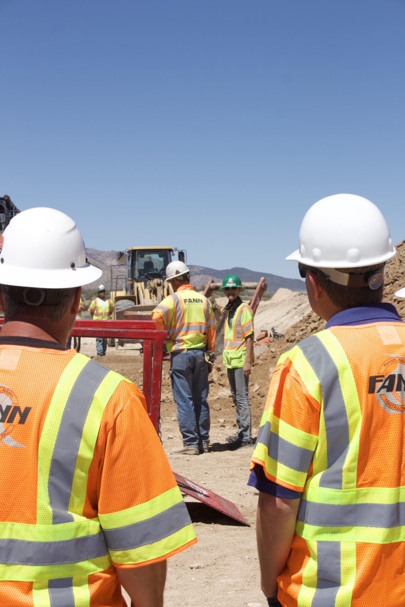 A group of construction workers preparing equipment for winter.