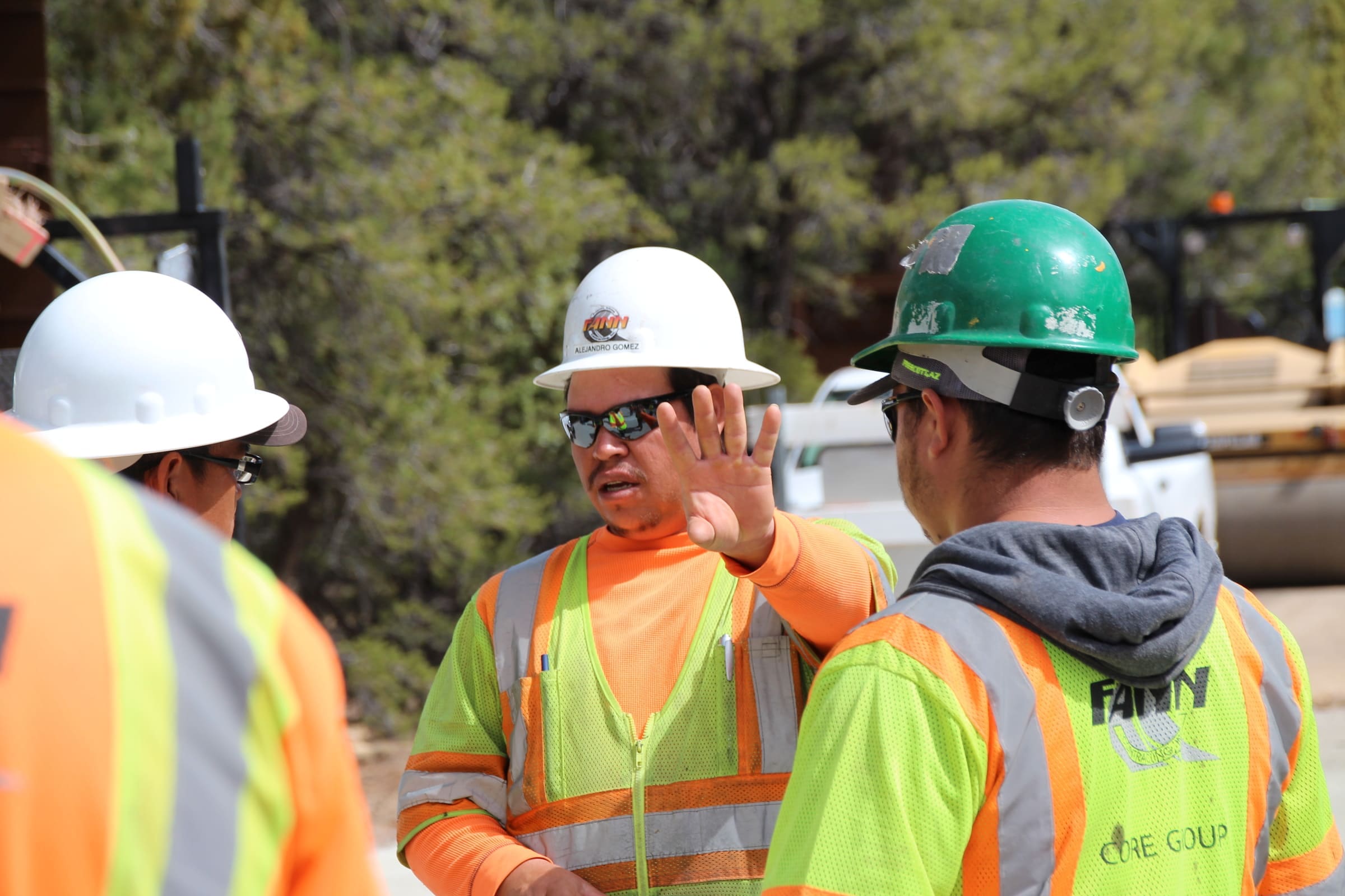 A group of construction workers talking to each other.