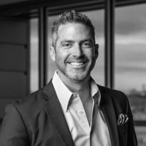 A black and white photo of a man in a suit represents Fann Contracting.