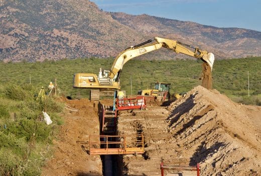 An intermediate excavator digging a trench for the offsite water phase 2.