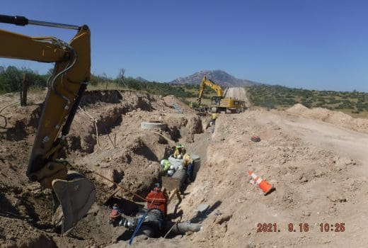 A construction crew is working on a dirt road.