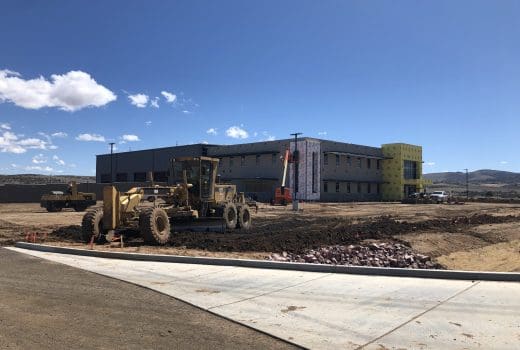 A construction site with a bulldozer in front of a building.