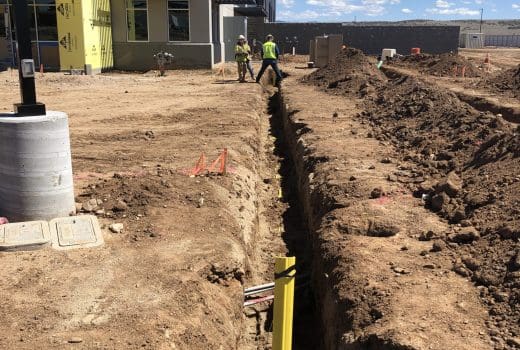 A trench is being dug in front of a building.
