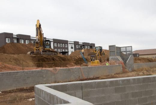 Dells View Apartments Phase 2 is having a concrete wall built in front of a house.